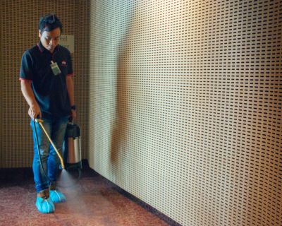 big red carpet cleaner specialist spraying formula to soften dirt for removal