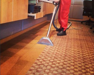 big red carpet cleaning specialist vacuuming commercial space